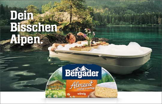 Bergader-Kampagnenmotiv für „Dein Bisschen Alpen“ mit Käsegenuss in alpiner Landschaft